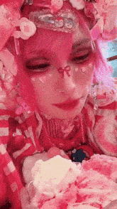 a girl with pink hair is eating ice cream with whipped cream on it