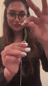 a woman wearing glasses is holding a green plant with a sticker that says " i love you "