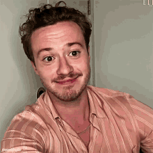 a man with a beard wearing a pink striped shirt