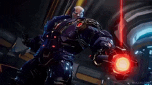 a man in a futuristic suit is holding a red light in his hand .