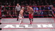 two wrestlers are in a ring with the word all in on the floor