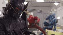 a group of superheros are fighting in a room and one of them is wearing a black mask