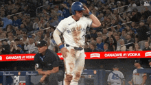a baseball player wearing a blue jays uniform stands on the field