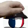 a hand is holding a hat with a red , white and blue ribbon on it .