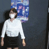 a woman wearing a mask and glasses is standing in front of a poster that says welcome