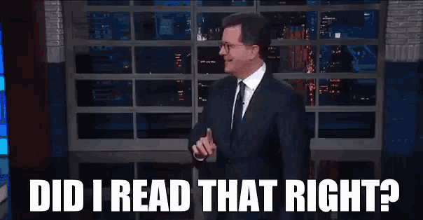 a man in a suit and tie is standing in front of a window and says `` did i read that right '' .
