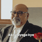 a bald man with glasses and a beard says ab rulayaga kya