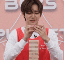 a man wearing a red shirt that says boys on planet