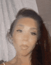 a close up of a woman 's face with long hair and a shaved head .