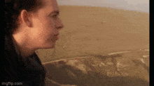 a close up of a person looking out over a desert
