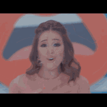a woman in a pink dress making a peace sign