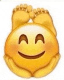 a smiley face with feet on it is being held by someone .