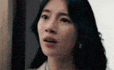 a close up of a woman 's face with her mouth open and a surprised look on her face .