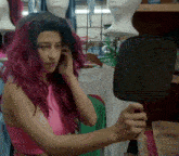 a woman with red hair is looking in a mirror
