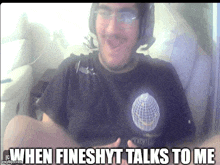 a man wearing headphones and a black shirt with a globe on it says when fineshyt talks to me