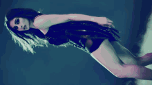 a woman in a black dress with feathers on her wings