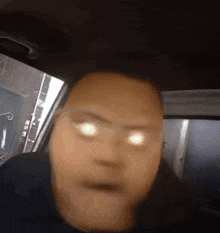 a close up of a person 's face with glowing eyes in a car