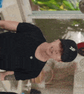 a man wearing a black shirt and a hat with a star on it