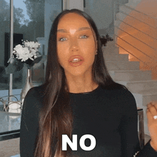 a woman in a black shirt says no in front of a staircase