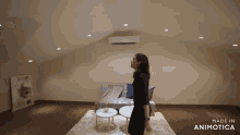a woman stands in a living room with the words made in animotica below her