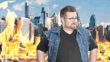 a man in a denim vest is standing in front of a burning city