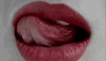 a close up of a woman 's mouth with her tongue out .