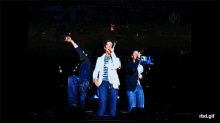 a group of people singing on a stage with rbd.gif written on the bottom