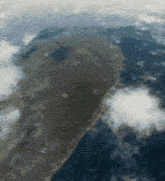an aerial view of a large body of water with a mountain in the background