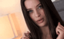 a woman with long hair and blue eyes is looking at the camera