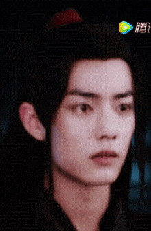 a close up of a young man 's face with chinese writing on the bottom right
