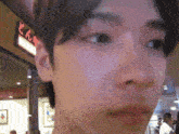 a close up of a man 's face with a sign in the background that says ' n ' on it