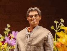a barbie doll is standing in front of a bunch of flowers