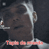 a close up of a man 's face with the caption tapia de mierda in red
