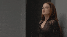 a woman leaning against a wall with her head turned