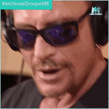 a man wearing sunglasses and headphones is making a funny face