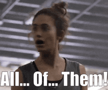 a woman is standing in a gym with her mouth open and says all of them !