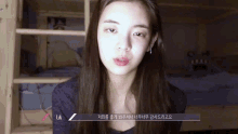 a woman without makeup is standing in front of a bed with a sign that says lia