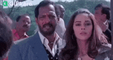 a man and a woman are standing next to each other and looking at each other .