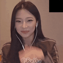a woman wearing ear buds with the hashtag @bmika on the bottom right