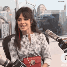 a woman wearing headphones is sitting in front of a microphone with a sign that says cnn on it