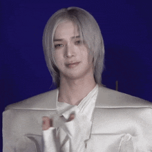 a man with long white hair is wearing a white shirt
