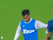 a man wearing a blue xep jersey stands on a soccer field