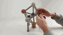 a person is playing with a toy made of magnets and balls