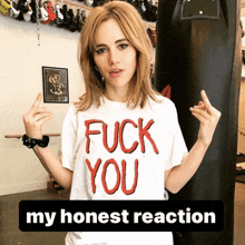 a woman wearing a t-shirt that says " fuck you " gives the middle finger
