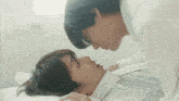 a man and a woman are kissing in bed