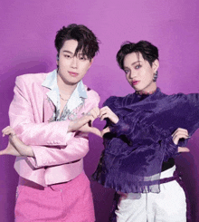 a man in a pink jacket is standing next to a man in a purple shirt