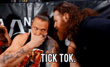 two men are looking at each other and one of them has the word tick on his face