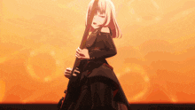 a girl in a black dress is holding a guitar in front of an orange background