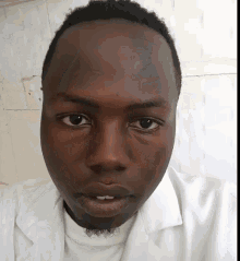 a close up of a man 's face with a white shirt