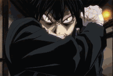 a person in a black suit is holding a sword in a dark room with a blue light coming out of it .